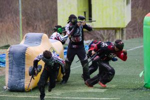 People engaged in paintball battle
